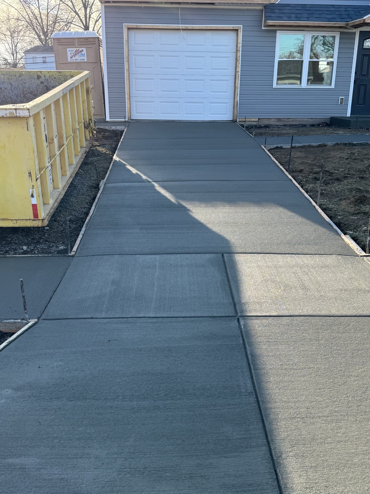 Freshly poured broom-finish concrete driveway