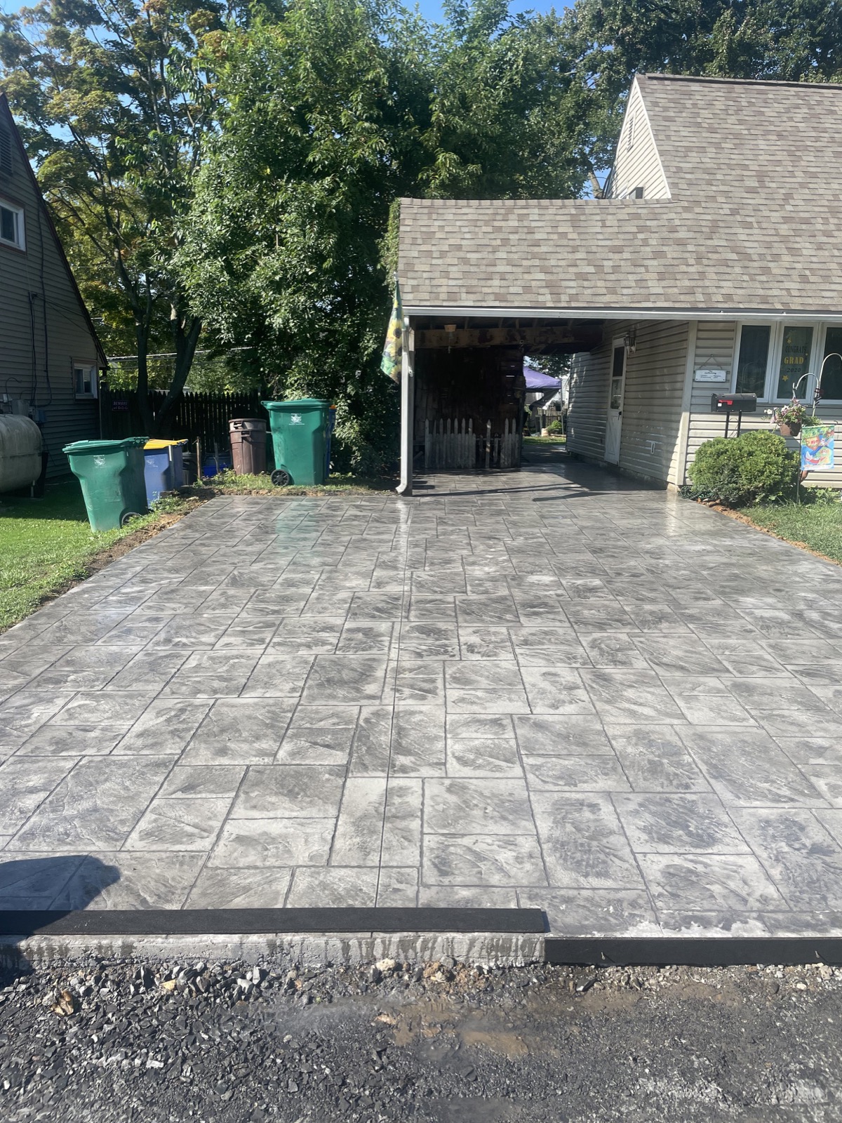 Stamped concrete driveway under a carport