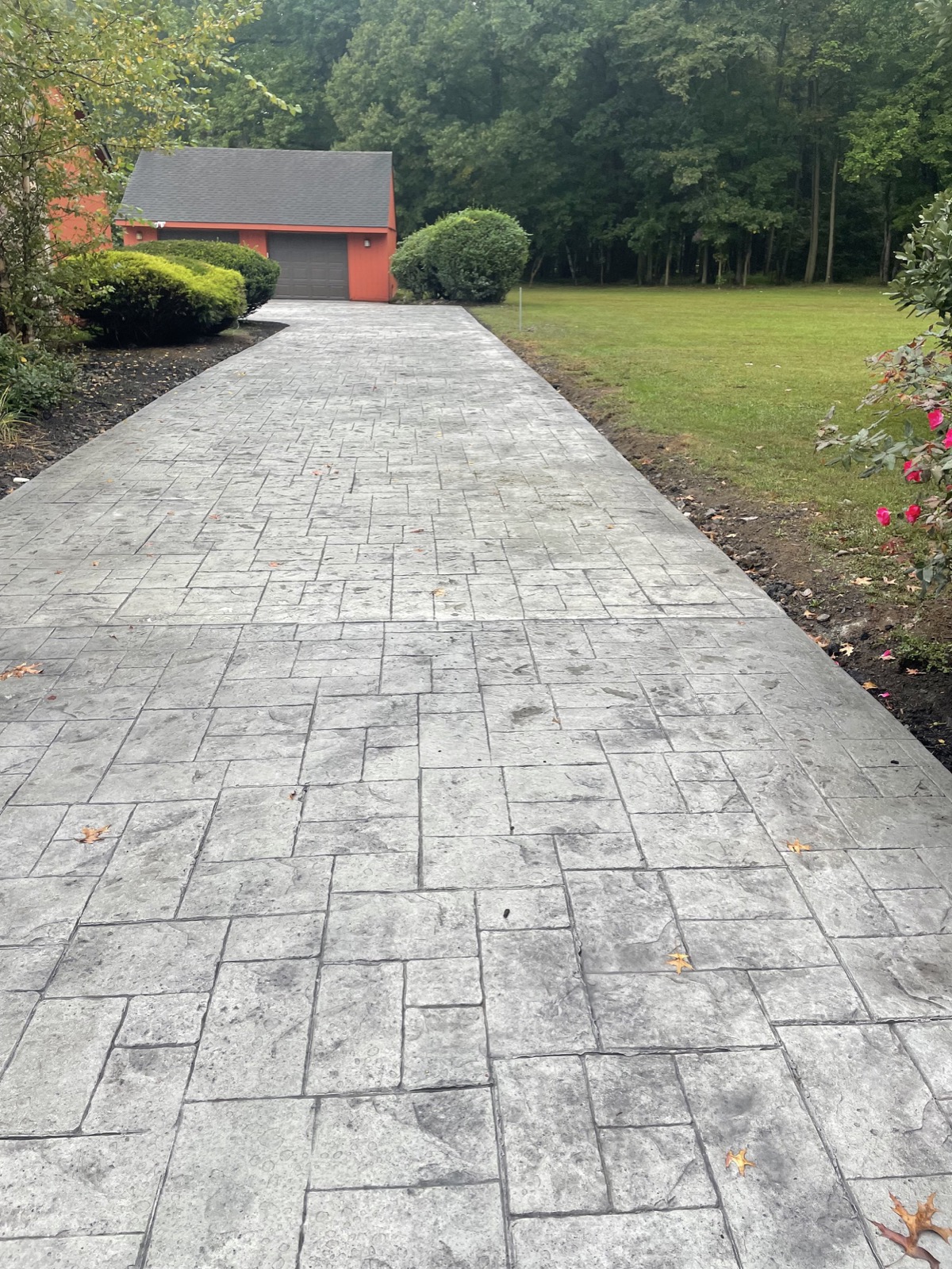 Gray stamped concrete driveway leading to a garage