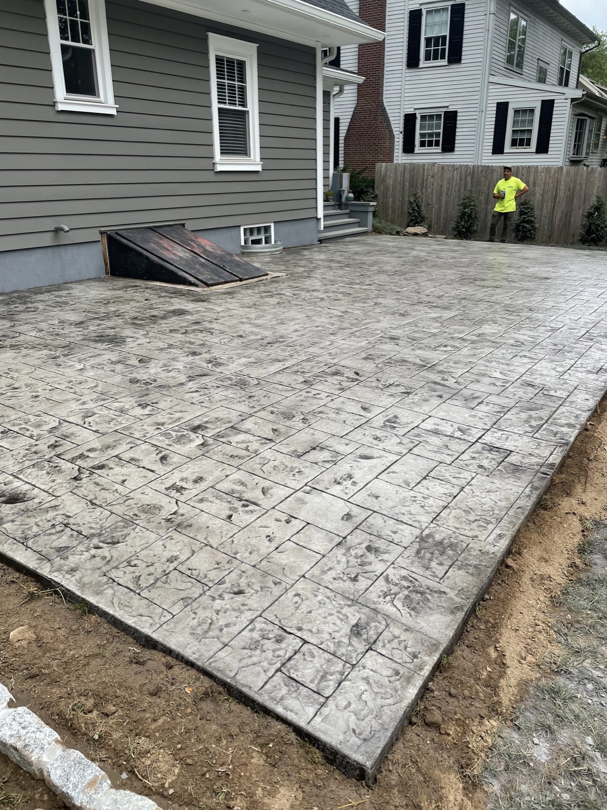 Gray stamped concrete patio behind a home
