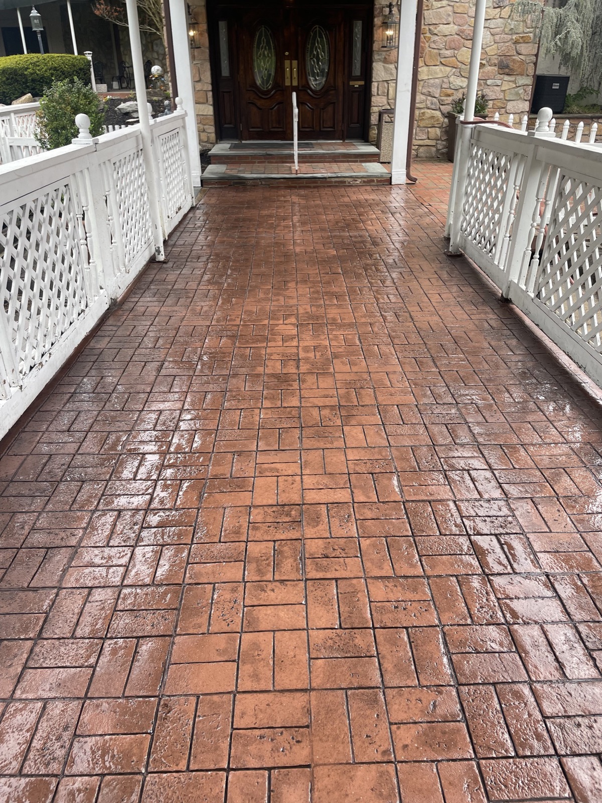Stamped brick-pattern concrete walkway leading to a front entrance